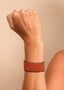 Pulseira de miçangas laranja feita pelo povo Waurá, artesanato indígena brasileiro