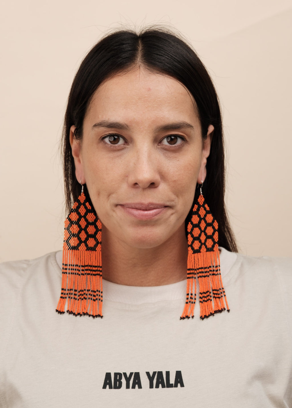 Brincos de miçangas laranja e preto feitos pelo povo Kayapó, artesanato indígena brasileiro 
