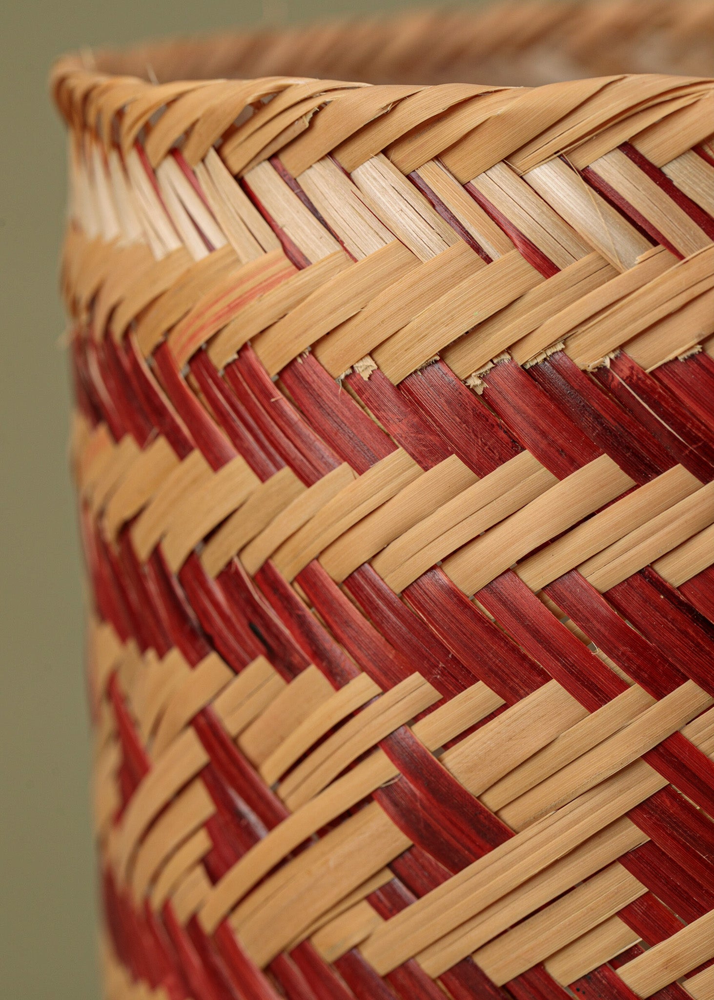 Cesto de fibra de arumã bege e vermelho feito pelo povo Ticuna, artesanato indígena brasileiro 