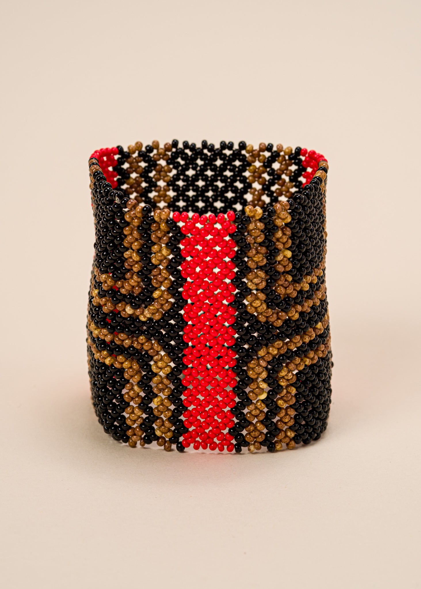 Pulseira de miçangas preta, vermelha e marrom feita pelo povo Waurá, artesanato indígena brasileiro
