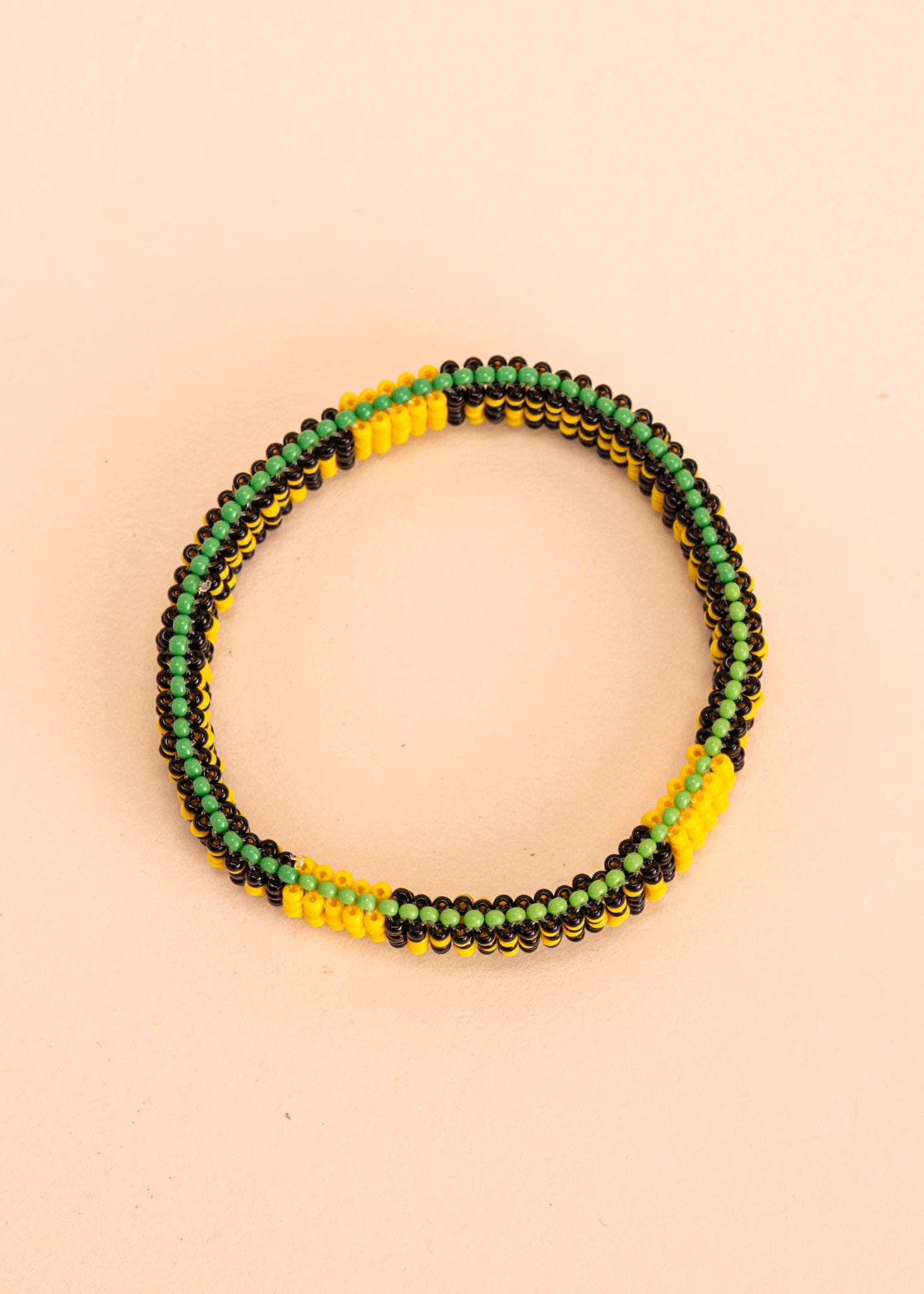 Pulseira de miçangas amarela, preta e verde feita pelo povo Waurá, artesanato indígena brasileiro 