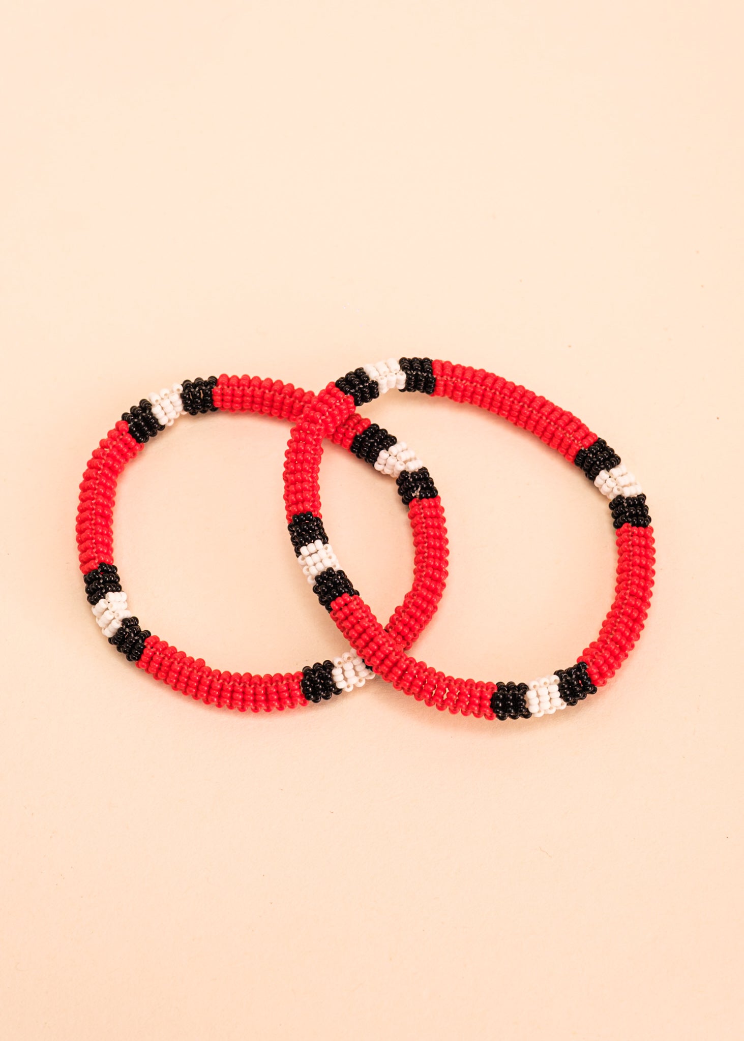 Dupla de pulseiras coral vermelha, preta e branca, feita pelo povo Waurá, artesanato indígena brasileiro