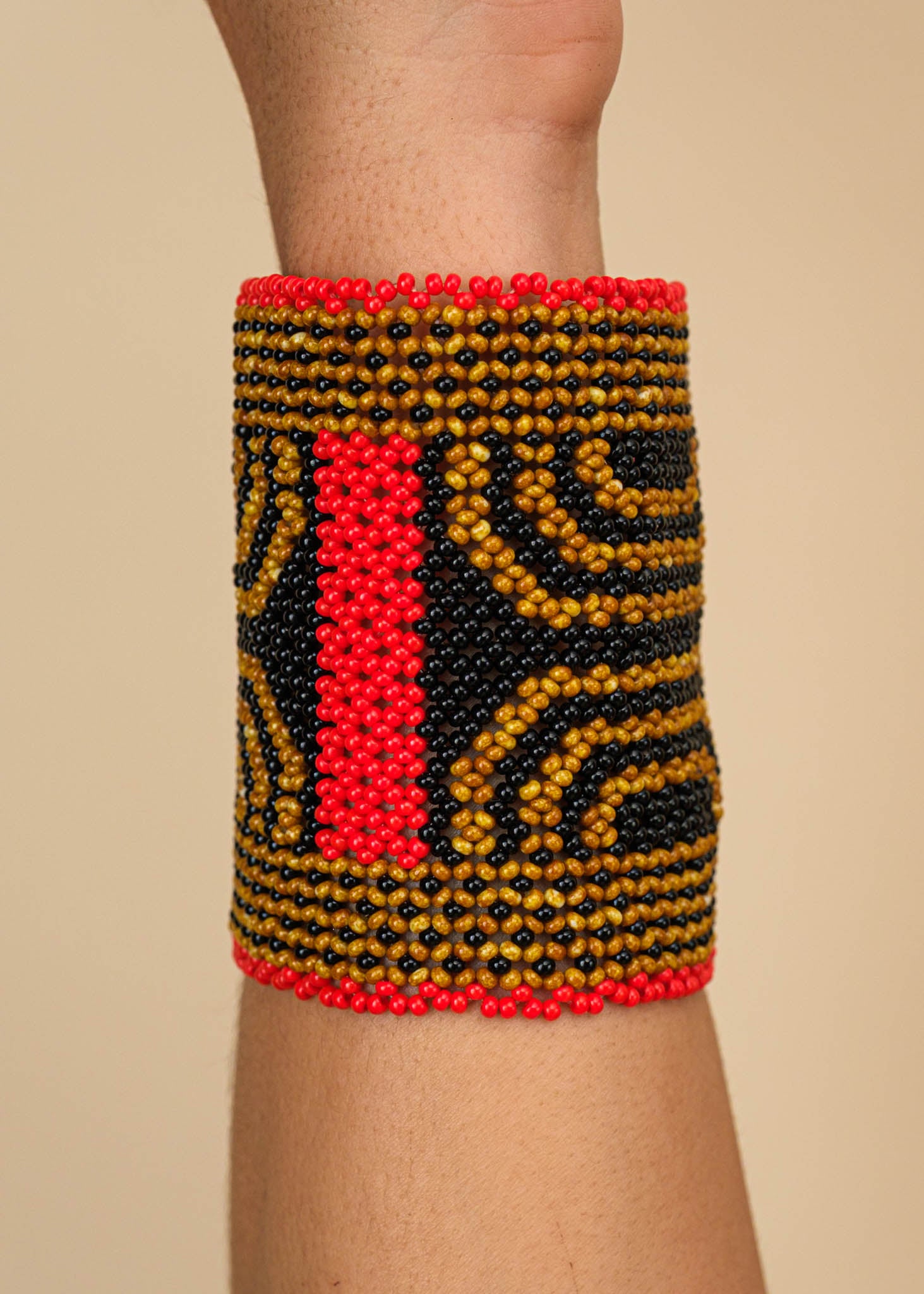Pulseira de miçangas marrom, preta e vermelha feita pelo povo Waurá, artesanato indígena brasileiro