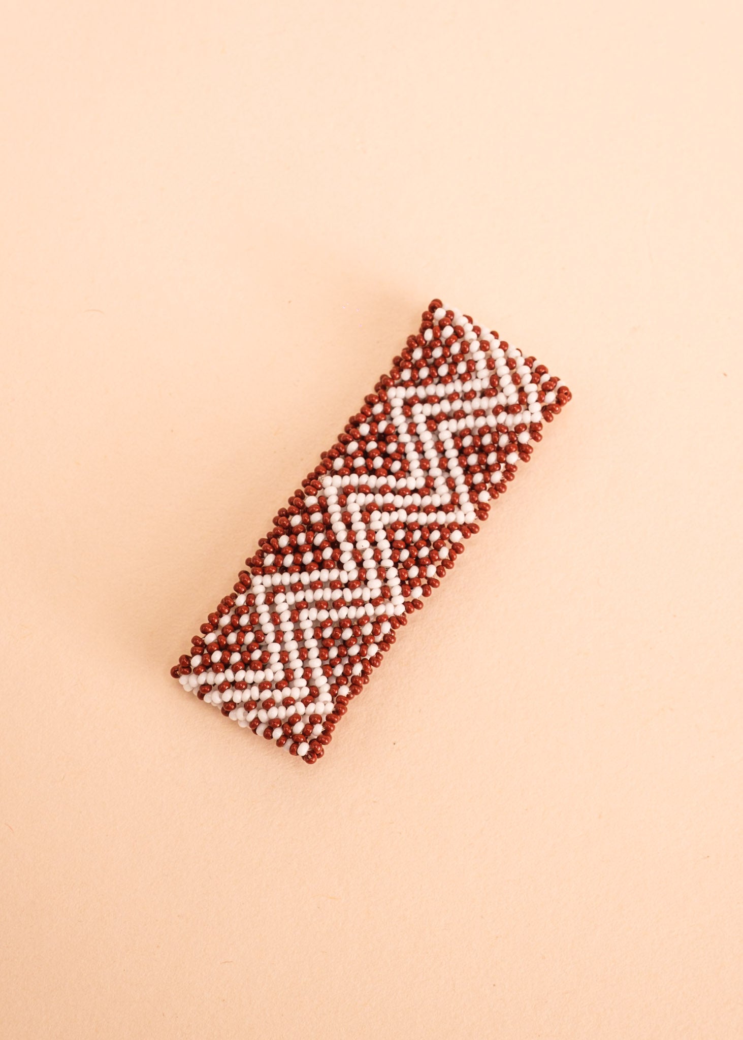 Pulseira de miçangas marrom e branca feita pelo povo Waurá, artesanato indígena brasileiro