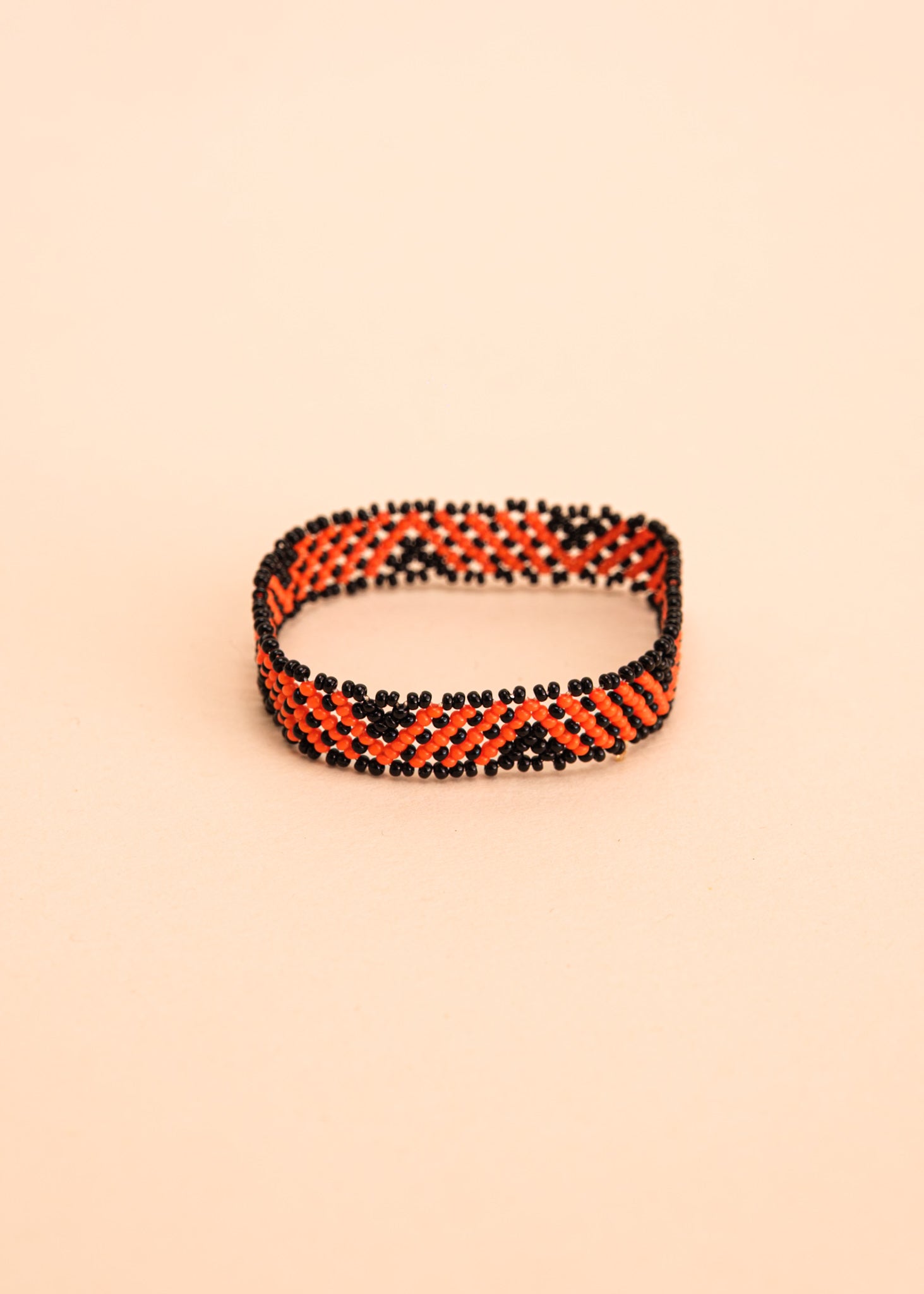 Pulseira de miçangas laranja feita pelo povo Waurá, artesanato indígena brasileiro