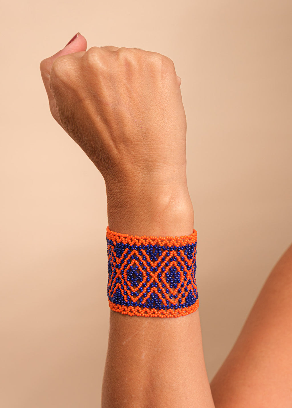 Pulseira de miçangas laranja e azul feita pelo povo Waurá, artesanato indígena brasileiro