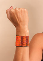 Pulseira de miçangas laranja feita pelo povo Waurá, artesanato indígena brasileiro