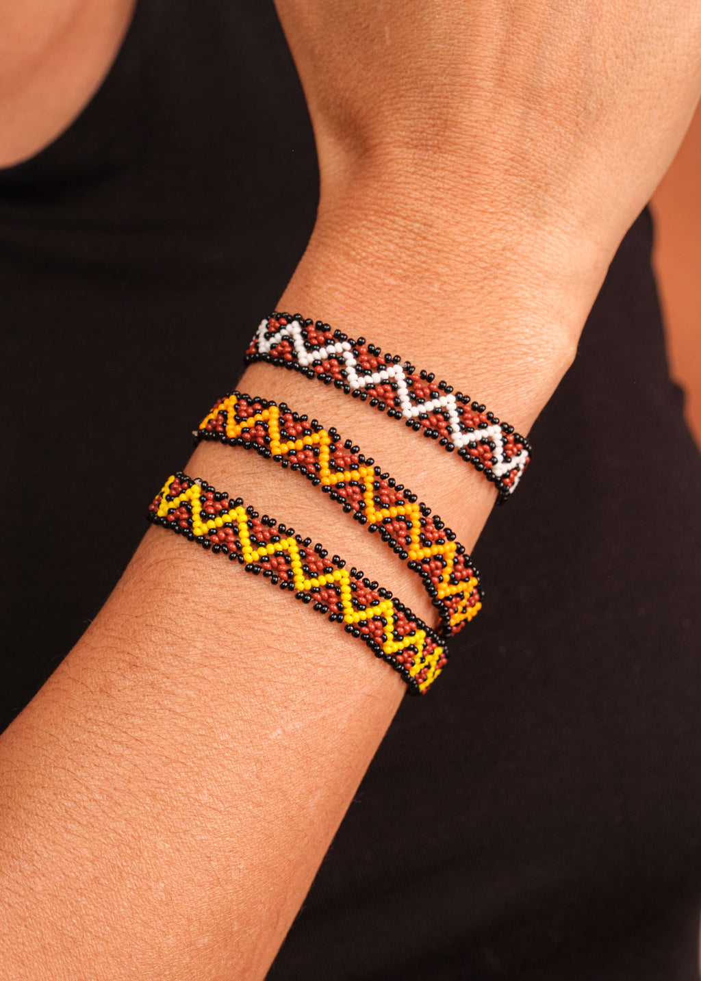 Pulseira de miçangas amarela e marrom feita pelo povo Waurá, artesanato indígena brasileiro