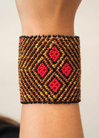 Pulseira de miçangas marrom e vermelha feita pelo povo Waurá, artesanato indígena brasileiro