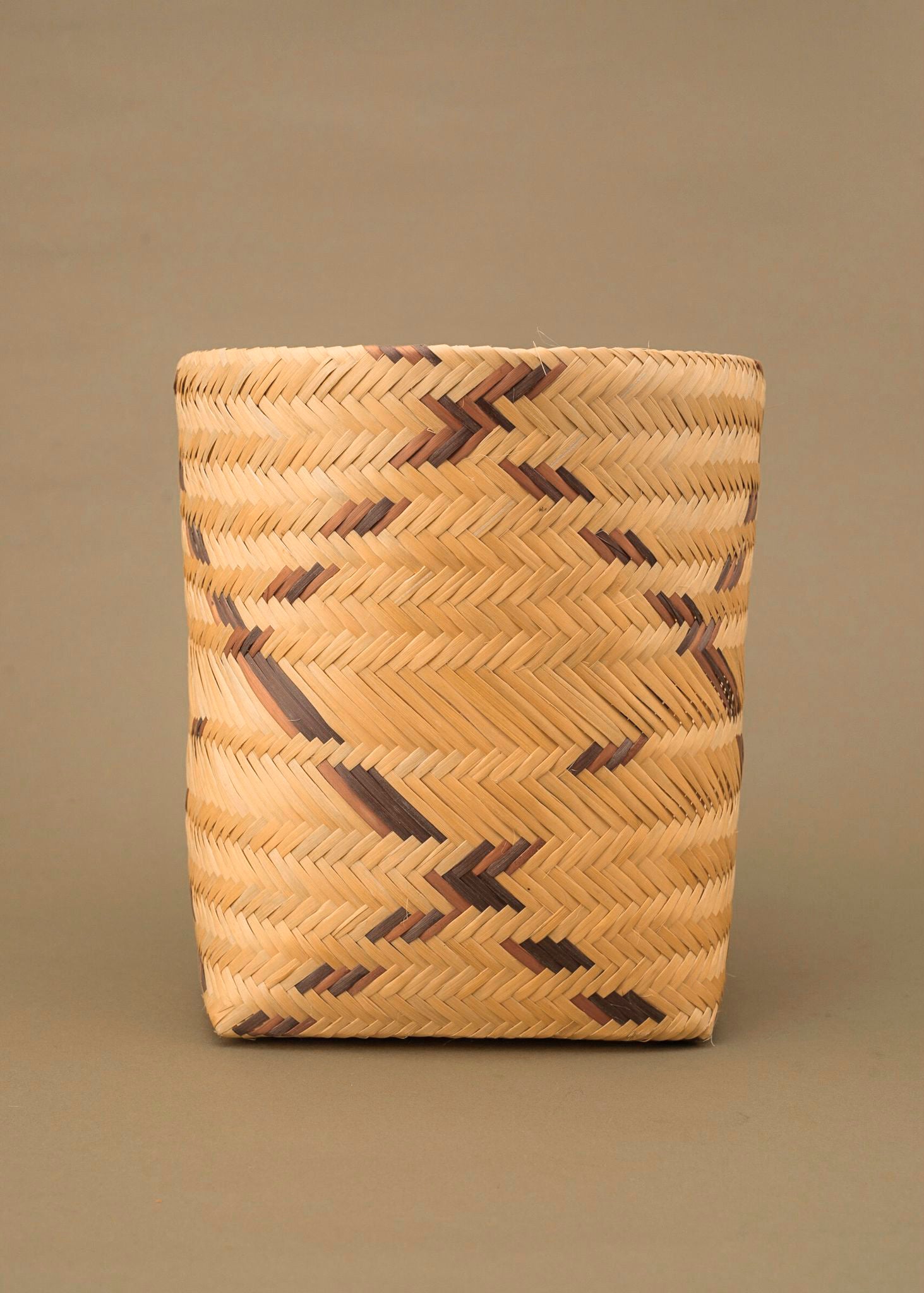 Cesto de fibra de cauaçu bege e marrom feito pelos povos do Teçume da Amazônia, artesanato indígena brasileiro 