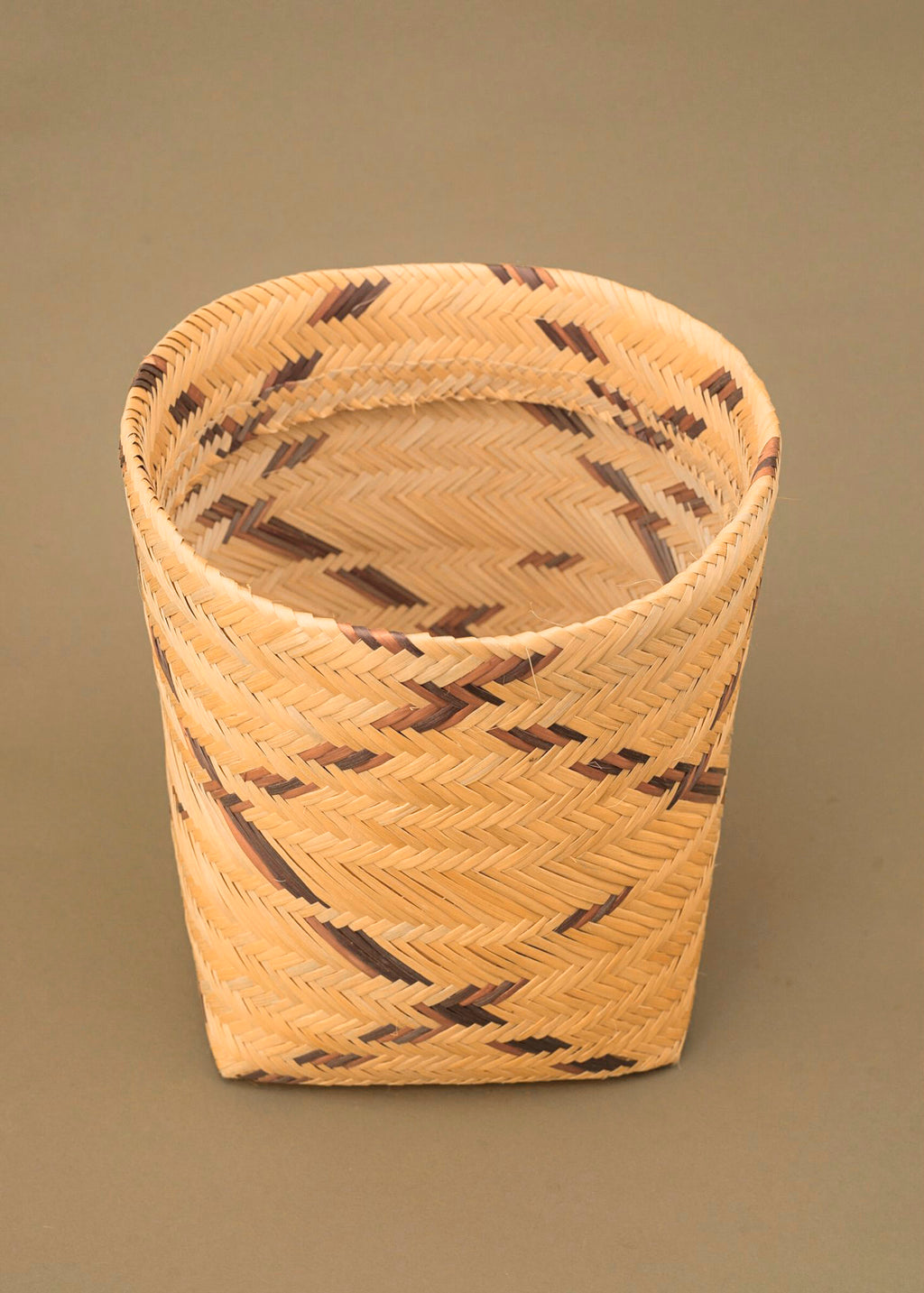 Cesto de fibra de cauaçu bege e marrom feito pelos povos do Teçume da Amazônia, artesanato indígena brasileiro 
