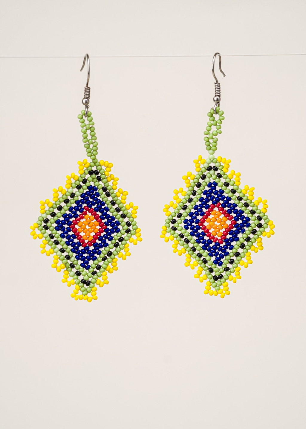 Brincos de miçangas verde, azul e amarelo feitos pelo povo Krahô, artesanato indígena brasileiro 