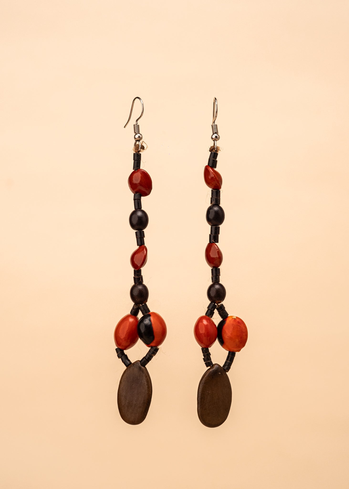 Brincos de sementes marrom, preto e vermelho feitos pelo povo Suruí, artesanato indígena brasileiro 