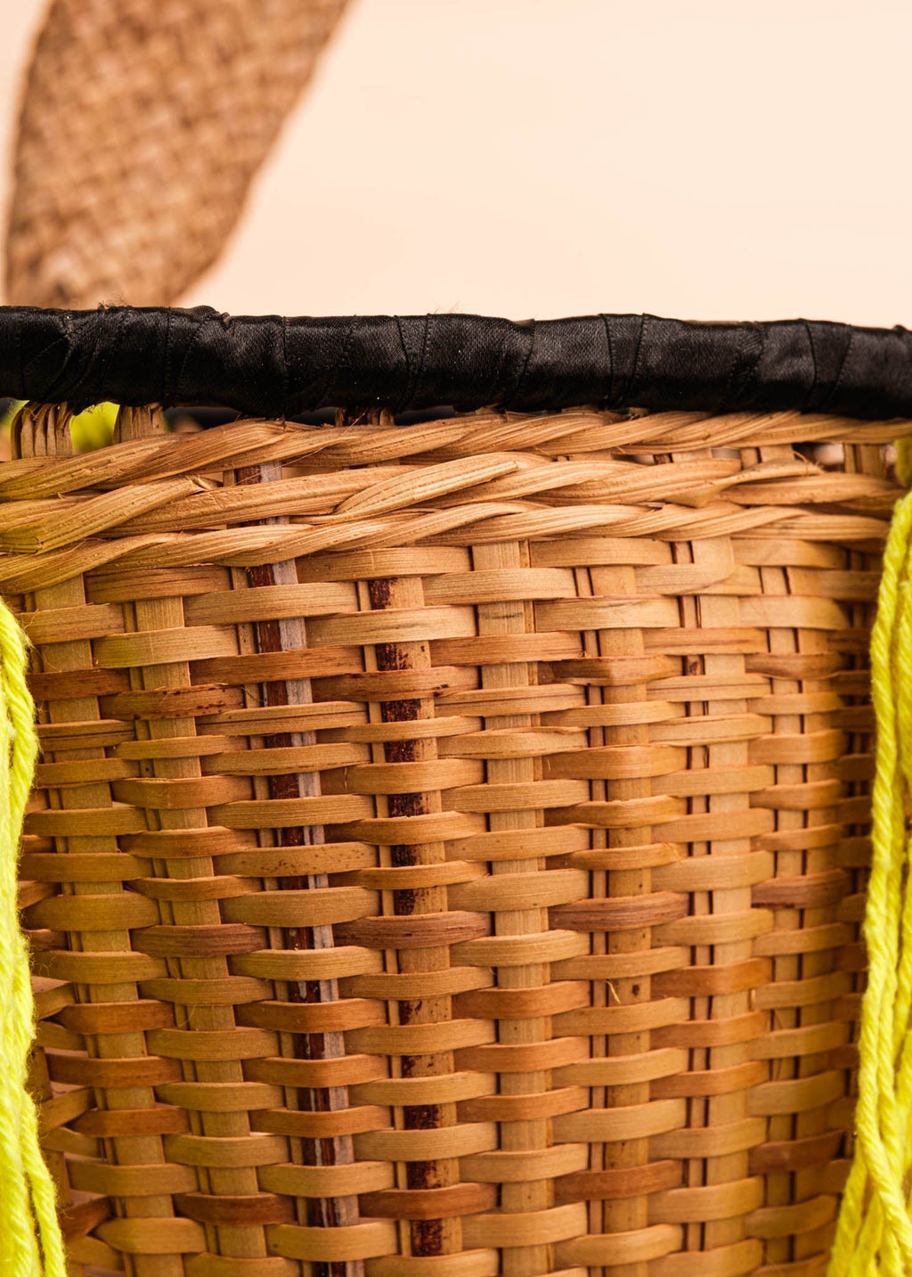 Cesto de fibras bege e verde feito por artesãs do povo Kayapó, artesanato indígena brasileiro 