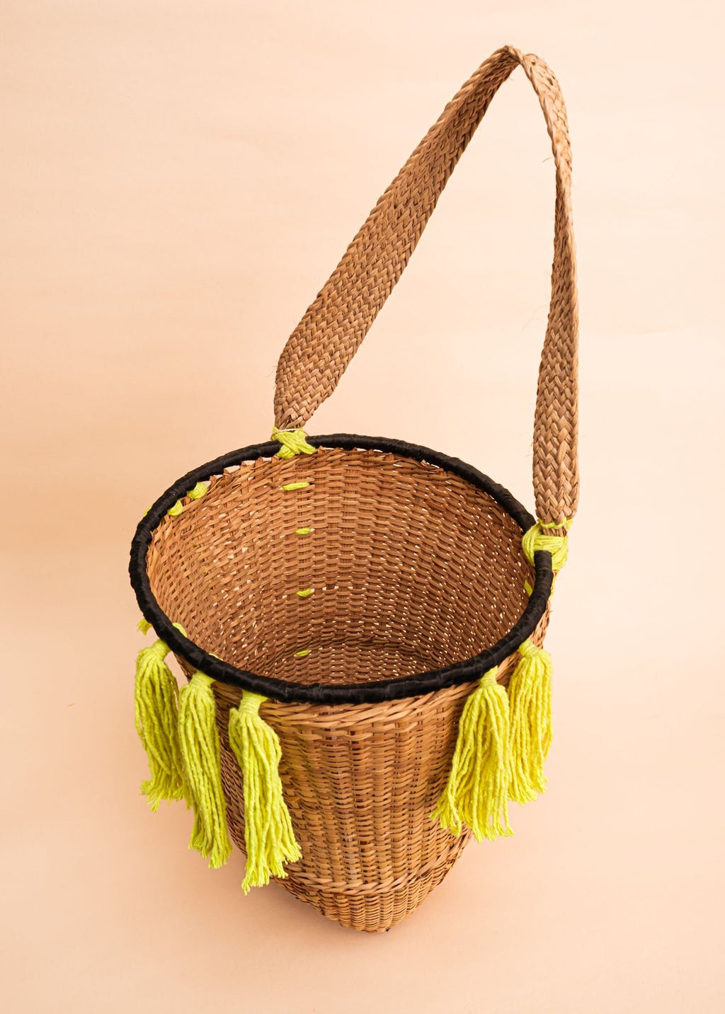 Cesto de fibras bege e verde feito por artesãs do povo Kayapó, artesanato indígena brasileiro 