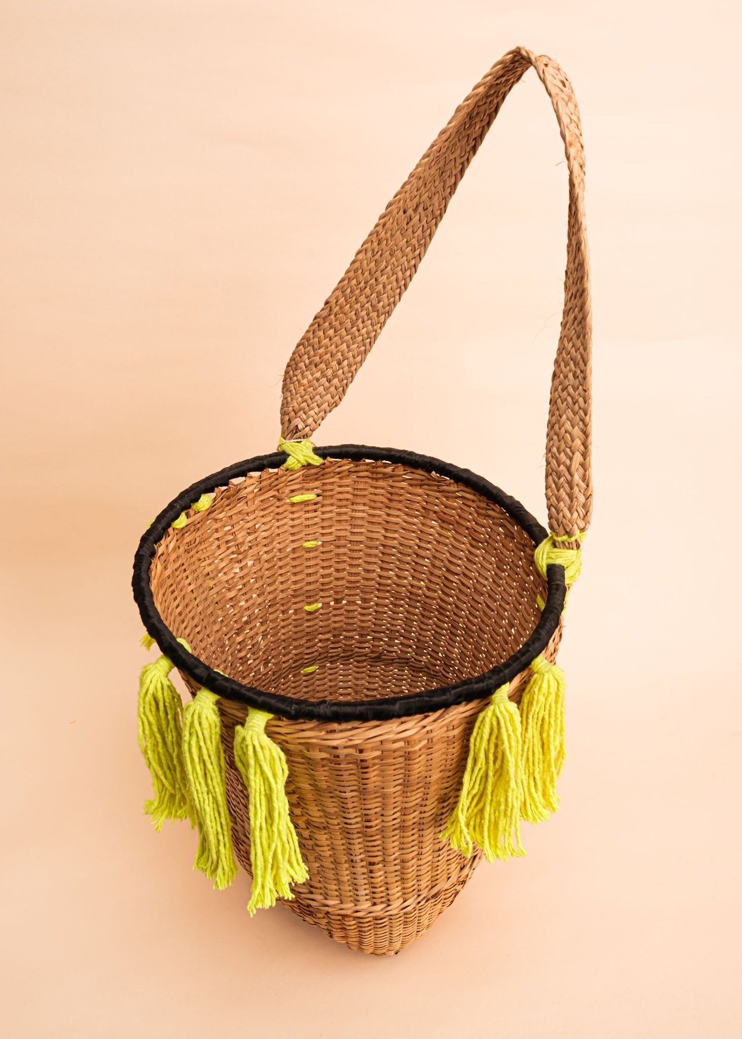 Cesto de fibras bege e verde feito por artesãs do povo Kayapó, artesanato indígena brasileiro 