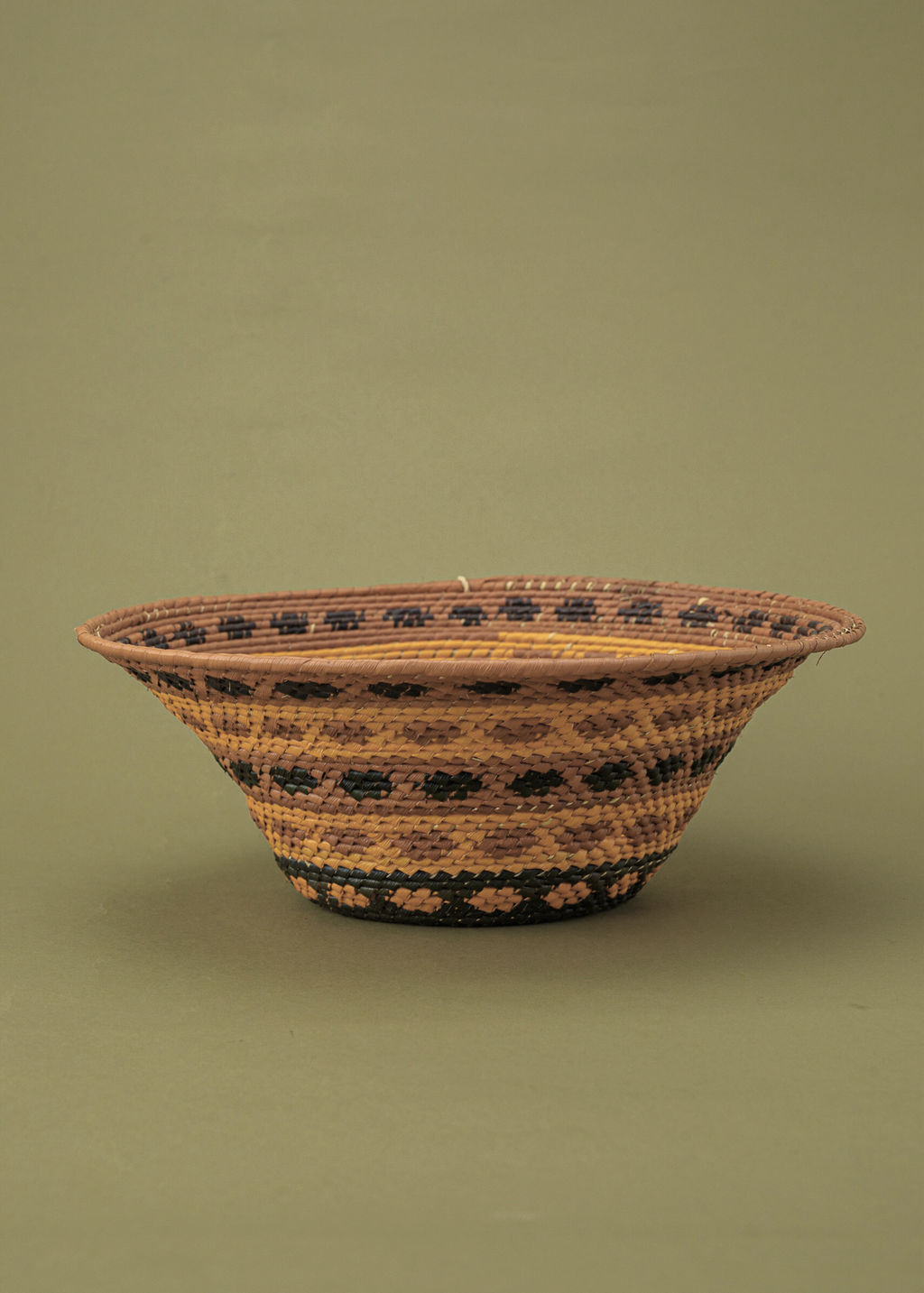 Cesto de fibras marrom e amarelo feito por artesãs da Tramas e Cores, artesanato indígena brasileiro