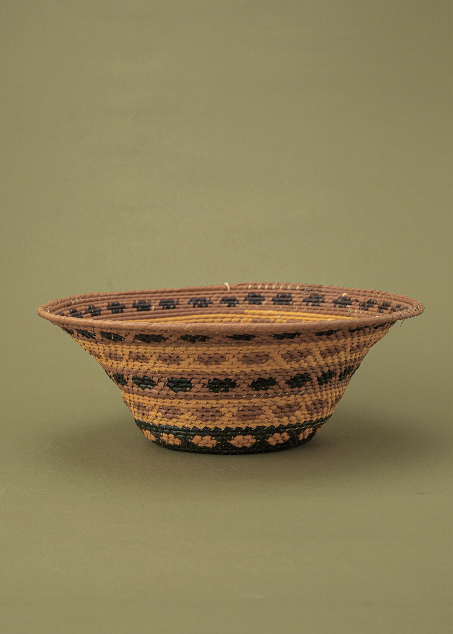 Cesto de fibras marrom e amarelo feito por artesãs da Tramas e Cores, artesanato indígena brasileiro