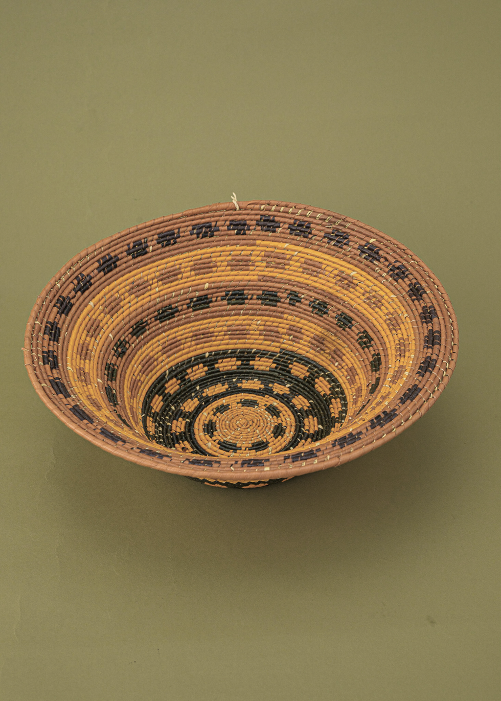 Cesto de fibras marrom e amarelo feito por artesãs da Tramas e Cores, artesanato indígena brasileiro