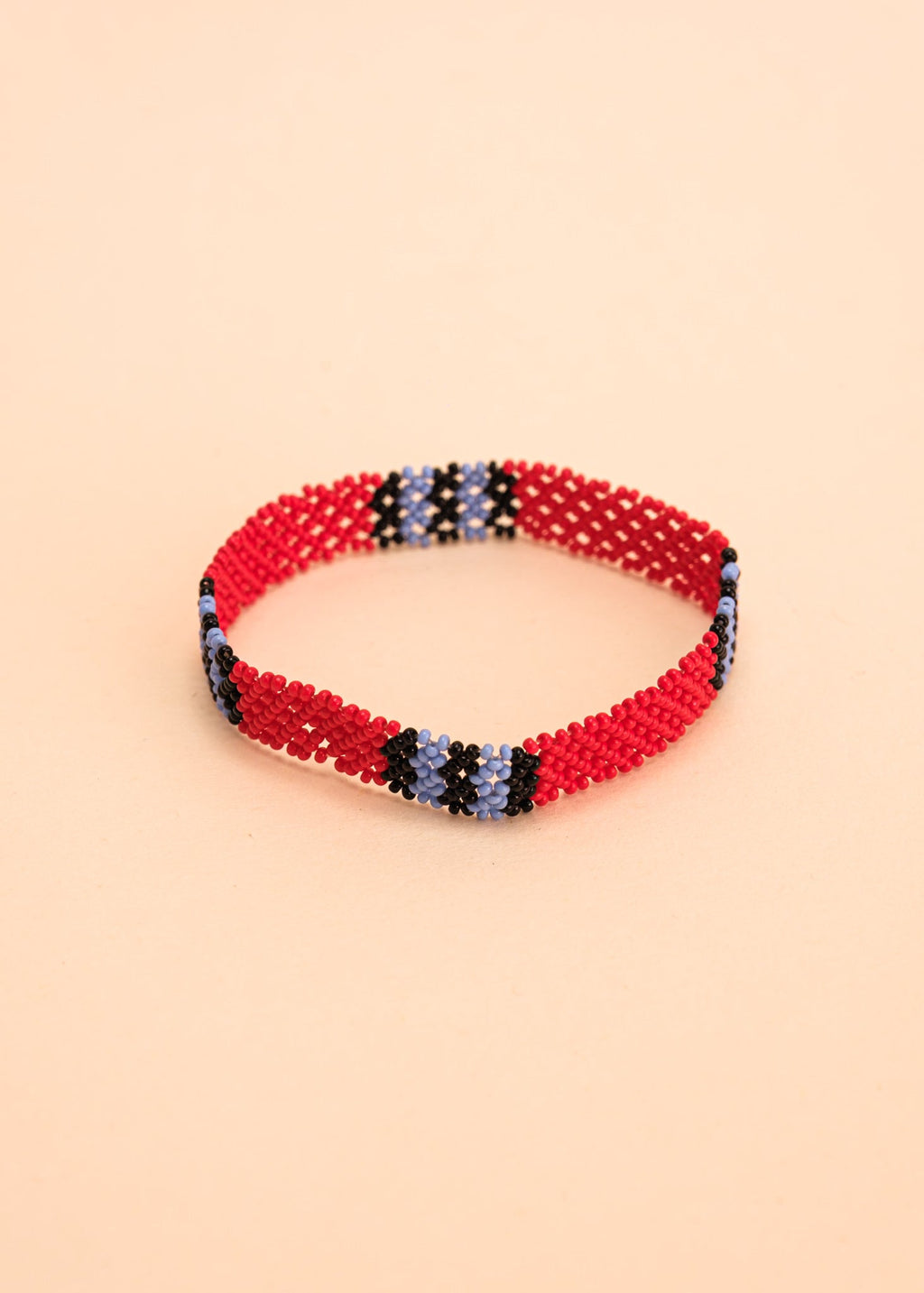 Pulseira de miçangas azul e vermelha feita pelo povo Waurá, artesanato indígena brasileiro 