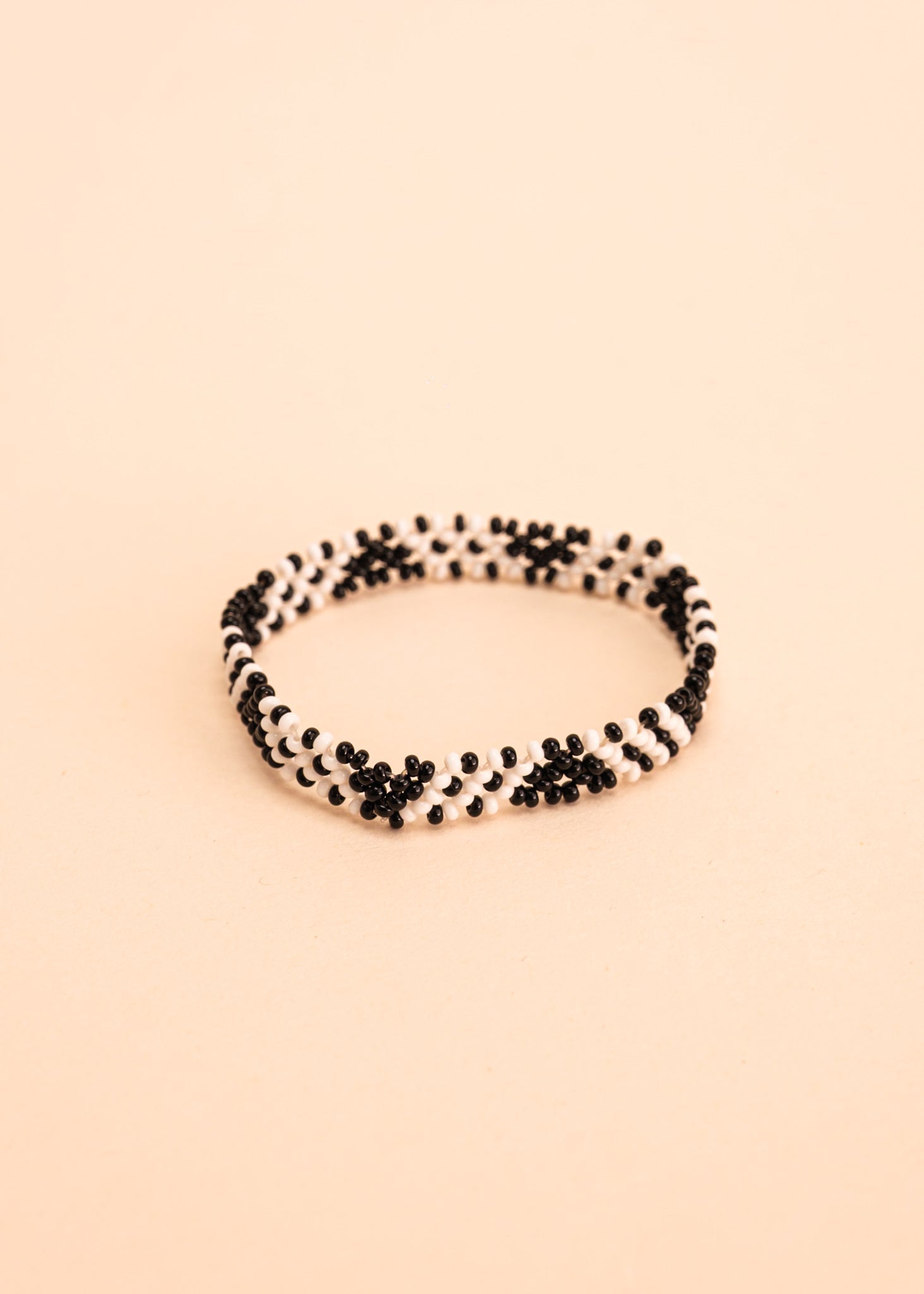 Pulseira de miçangas branca e preto feita pelo povo Waurá, artesanato indígena brasileiro