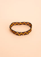 Pulseira de miçangas amarela e marrom feita pelo povo Waurá, artesanato indígena brasileiro