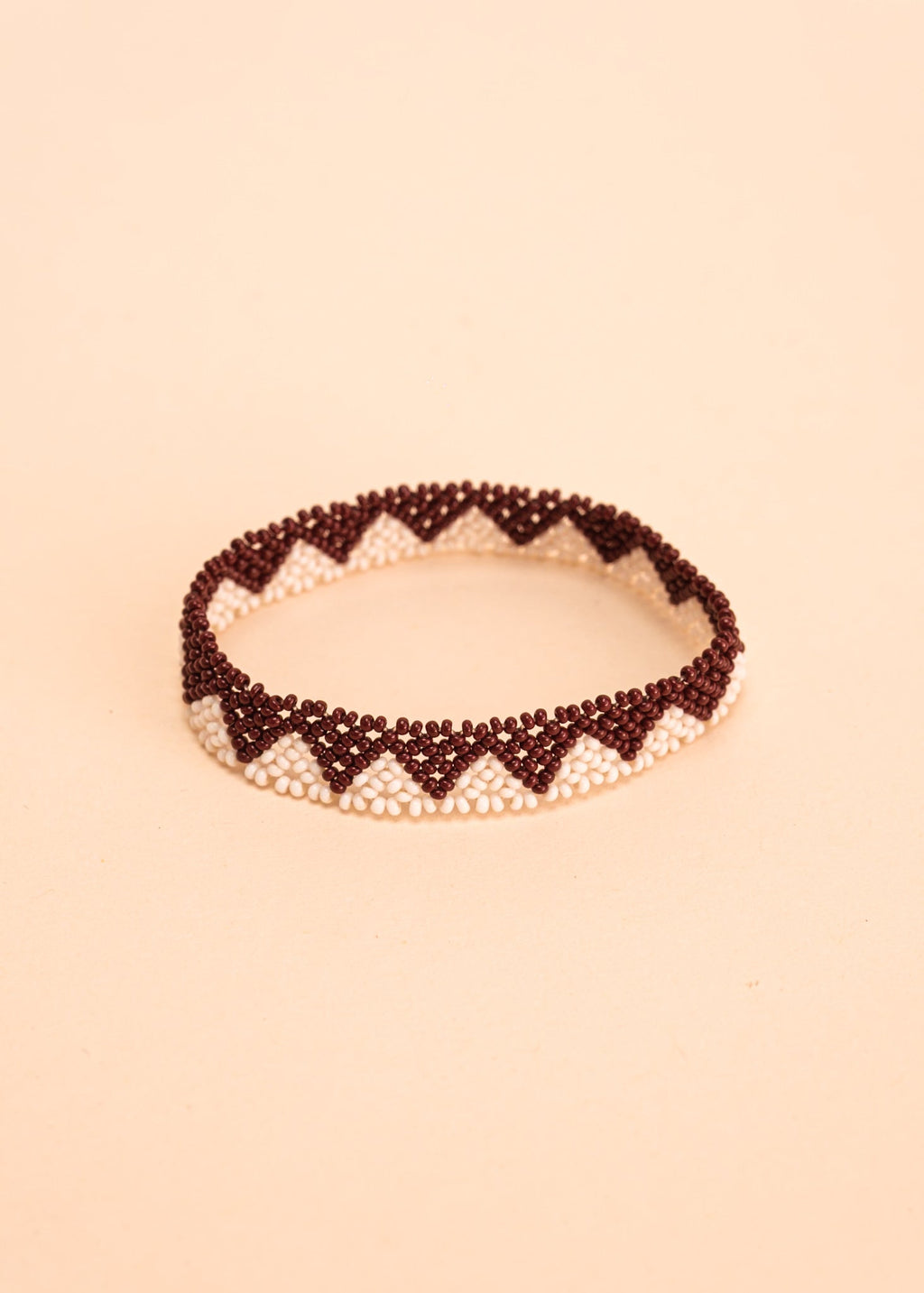 Pulseira de miçangas verde e marrom feita pelo povo Waurá, artesanato indígena brasileiro