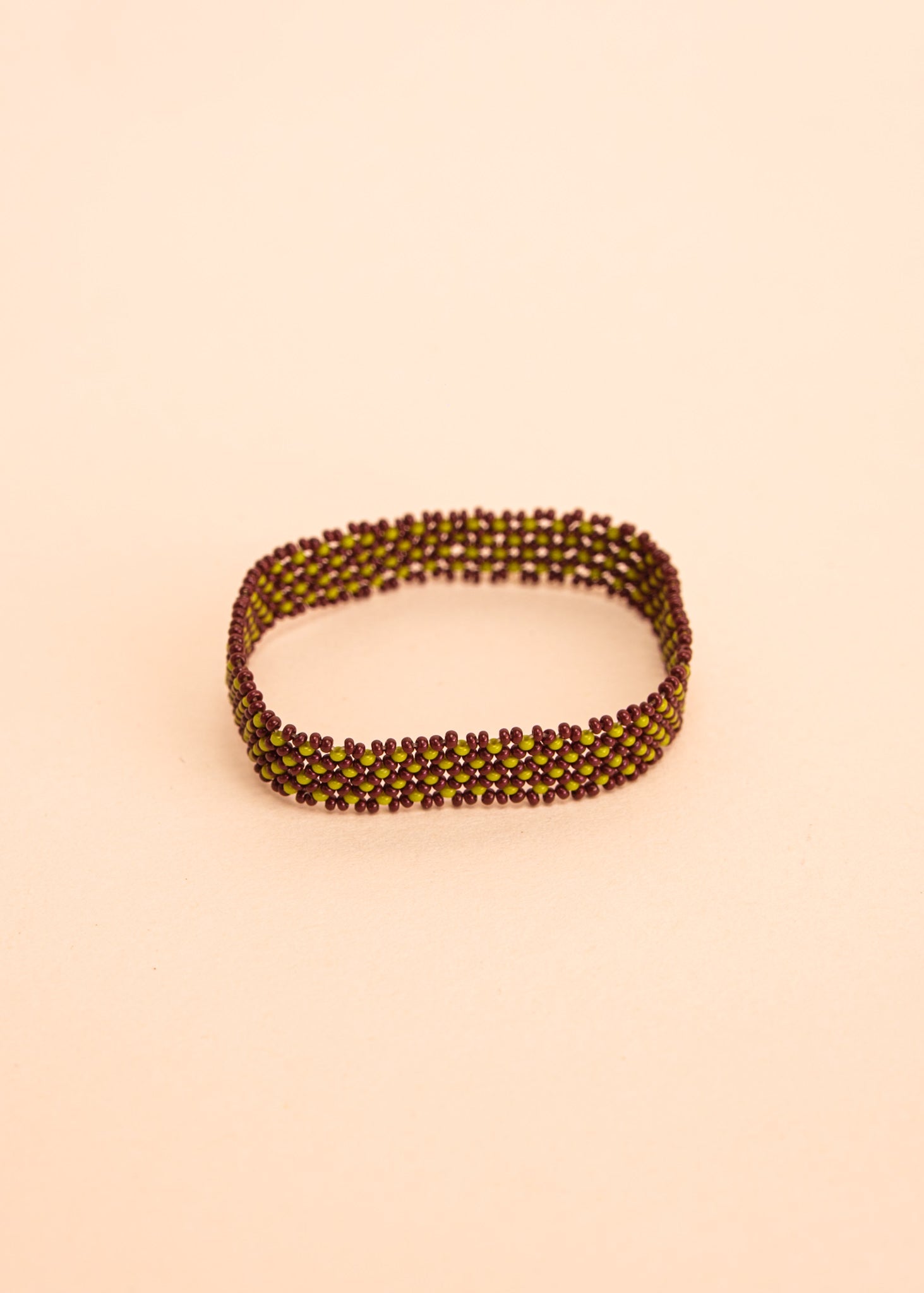 Pulseira de miçangas verde e marrom feita pelo povo Waurá, artesanato indígena brasileiro