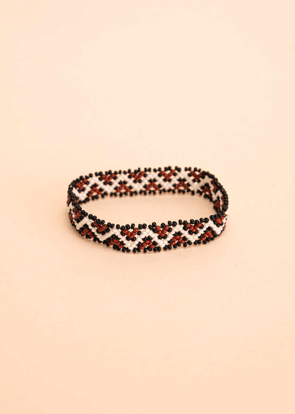Pulseira de miçangas branca e marrom feita pelo povo Waurá, artesanato indígena brasileiro