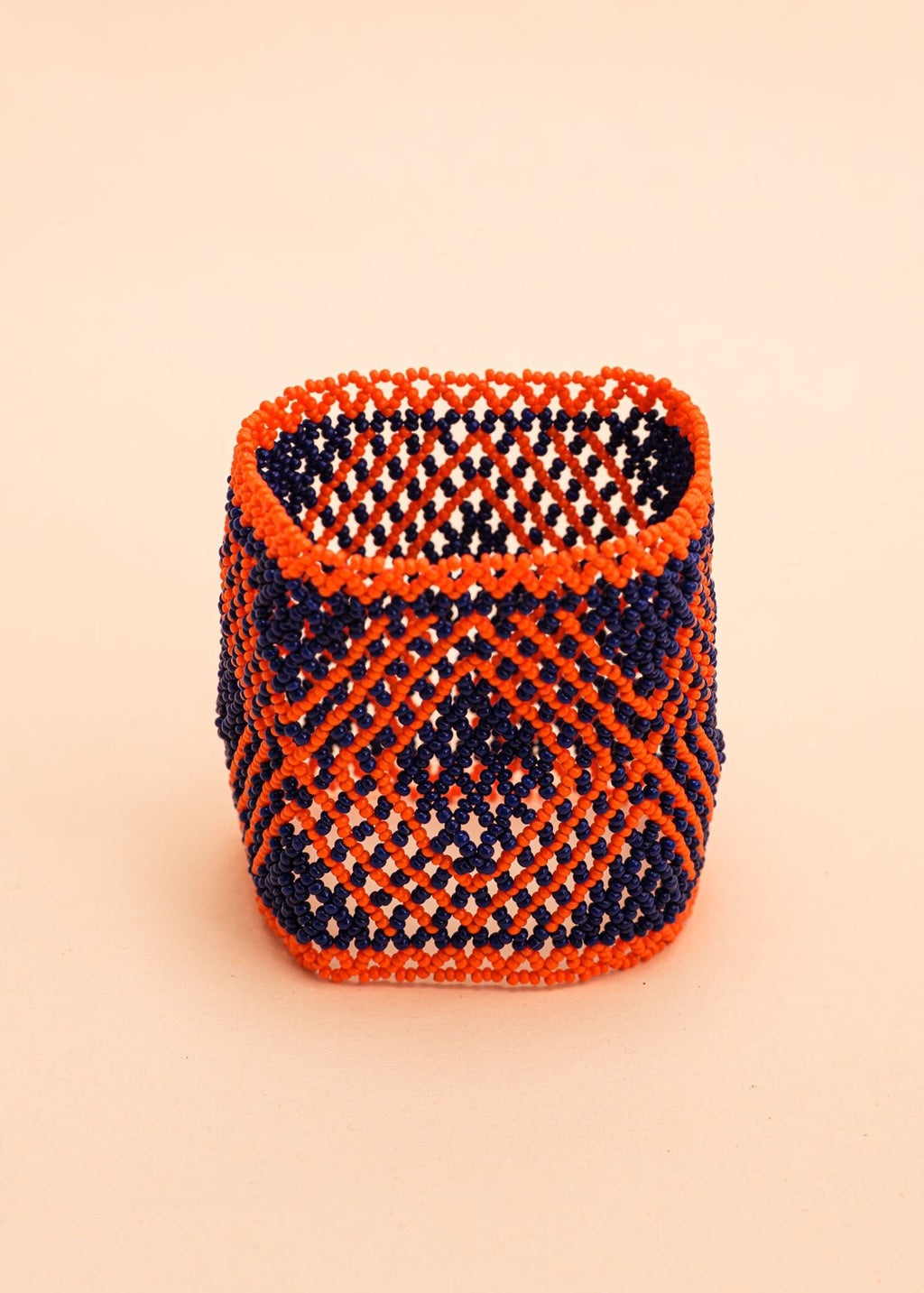 Pulseira de miçangas laranja e azul feita pelo povo Waurá, artesanato indígena brasileiro