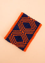 Pulseira de miçangas laranja e azul feita pelo povo Waurá, artesanato indígena brasileiro