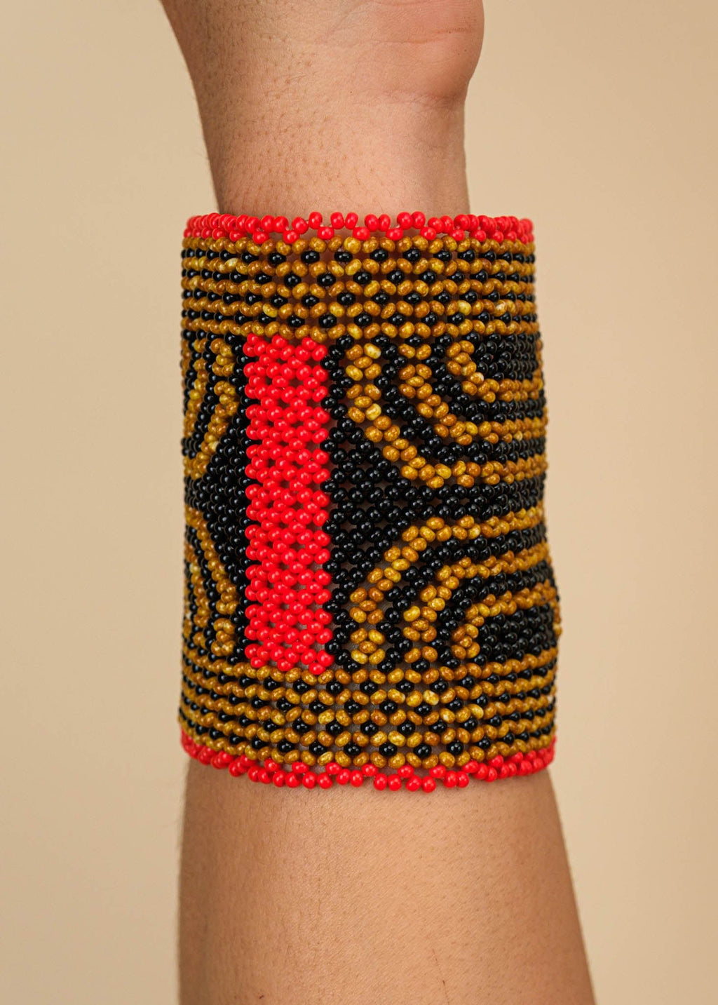 Pulseira de miçangas marrom, preta e vermelha feita pelo povo Waurá, artesanato indígena brasileiro