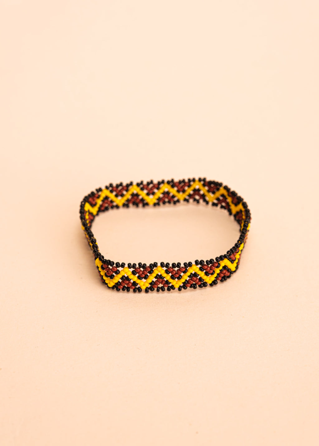 Pulseira de miçangas amarela e marrom feita pelo povo Waurá, artesanato indígena brasileiro