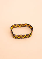 Pulseira de miçangas amarela e marrom feita pelo povo Waurá, artesanato indígena brasileiro