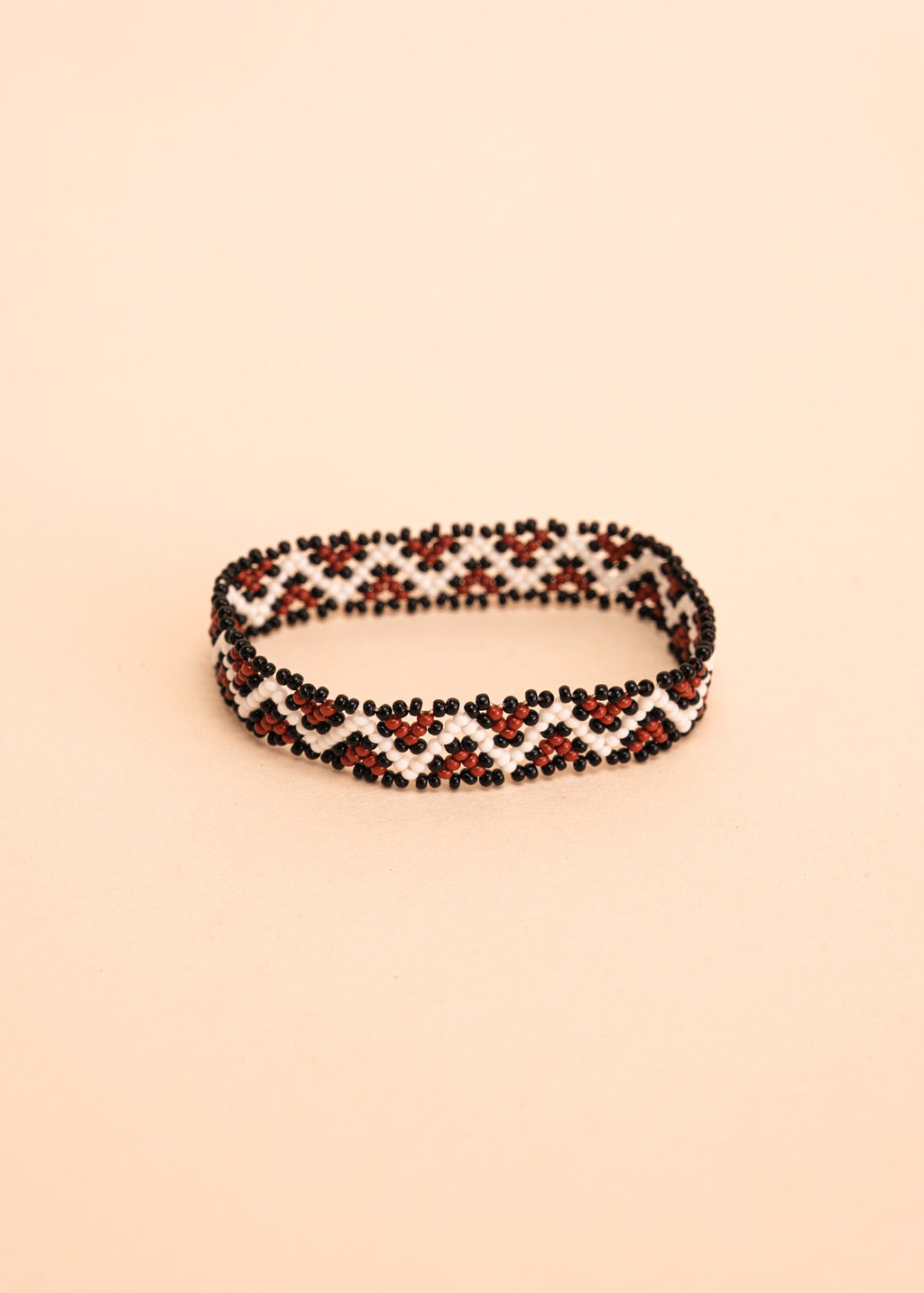 Pulseira de miçangas branca e marrom feita pelo povo Waurá, artesanato indígena brasileiro