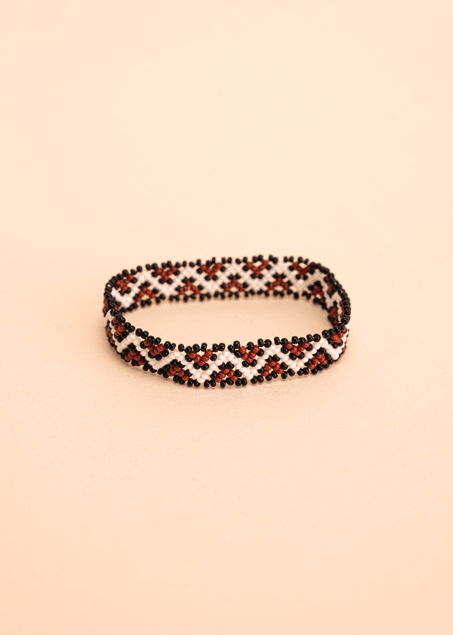 Pulseira de miçangas branca e marrom feita pelo povo Waurá, artesanato indígena brasileiro