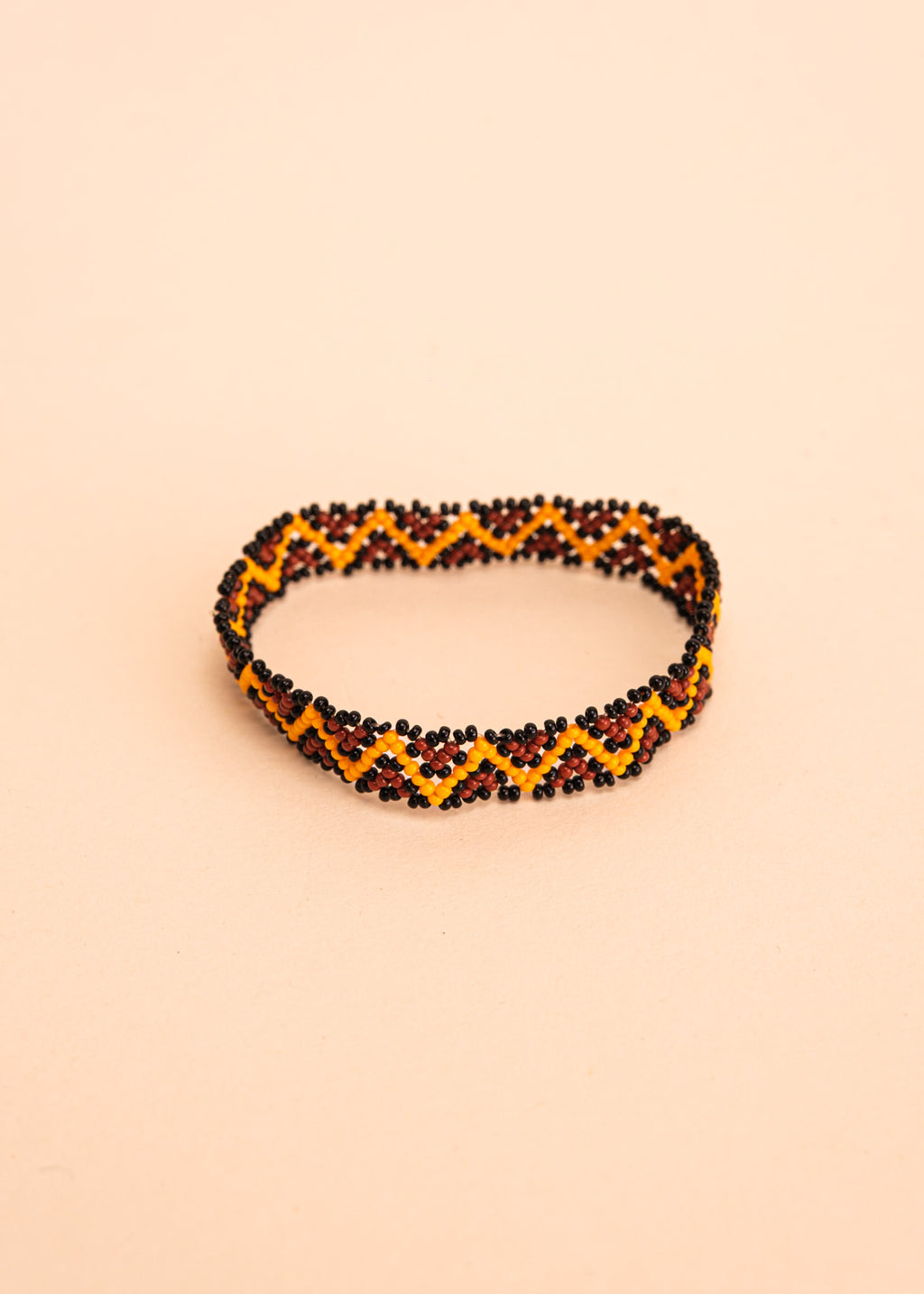 Pulseira de miçangas amarela e marrom feita pelo povo Waurá, artesanato indígena brasileiro