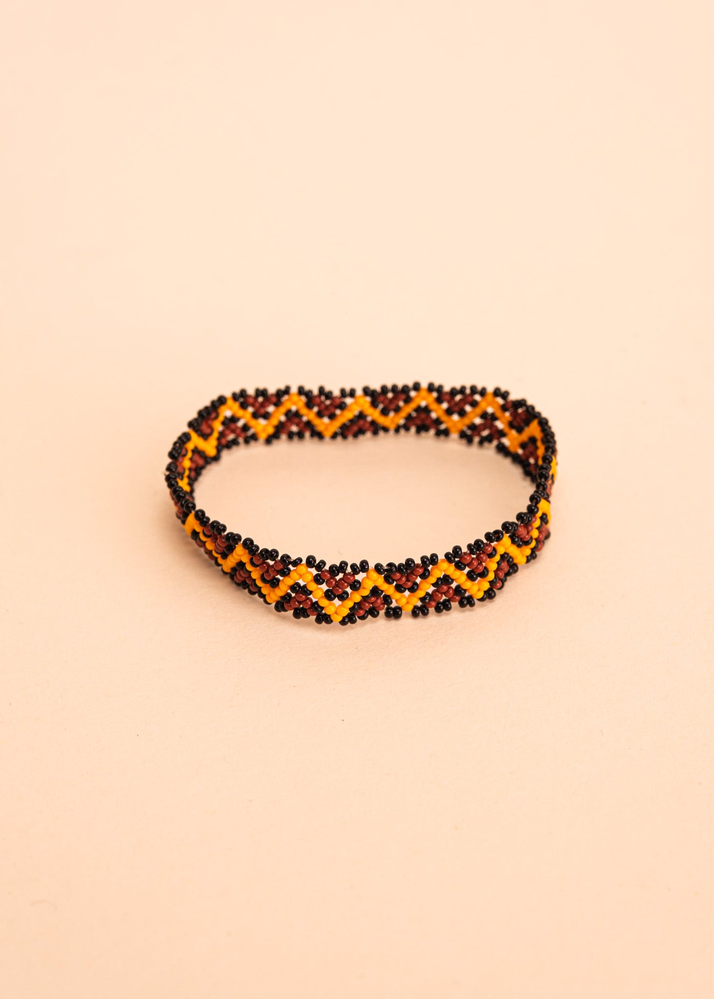 Pulseira de miçangas amarela e marrom feita pelo povo Waurá, artesanato indígena brasileiro