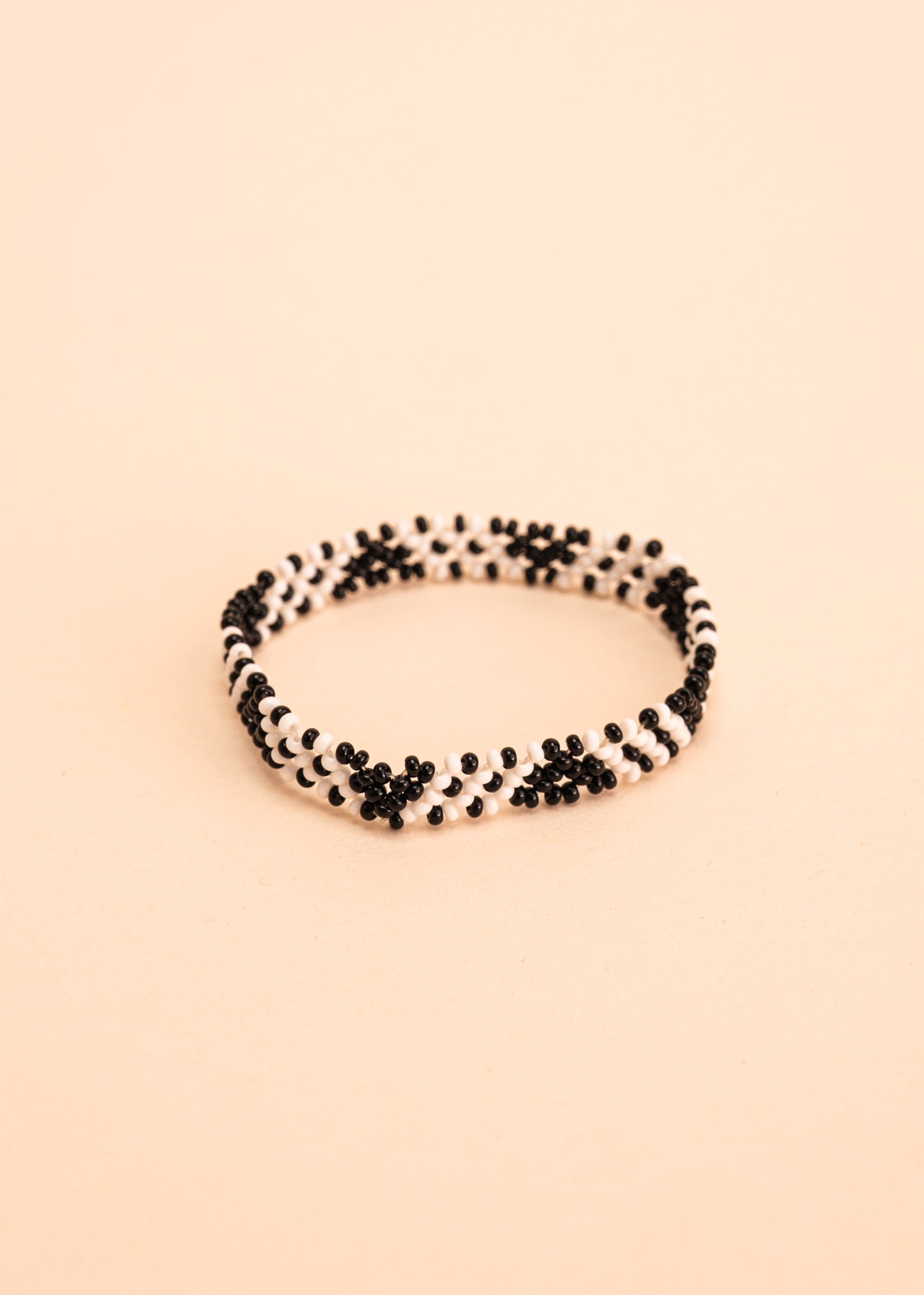 Pulseira de miçangas branca e preto feita pelo povo Waurá, artesanato indígena brasileiro